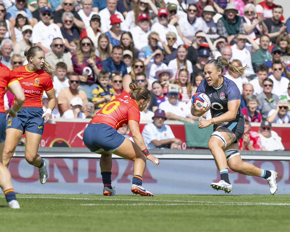 Maddie Feaunati of England Red Roases breaking through the Spanish defence